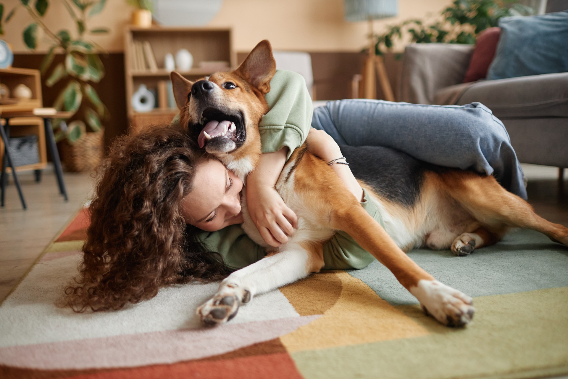 Girl Playing with Happy Dog Fooling Around on Floor at Home